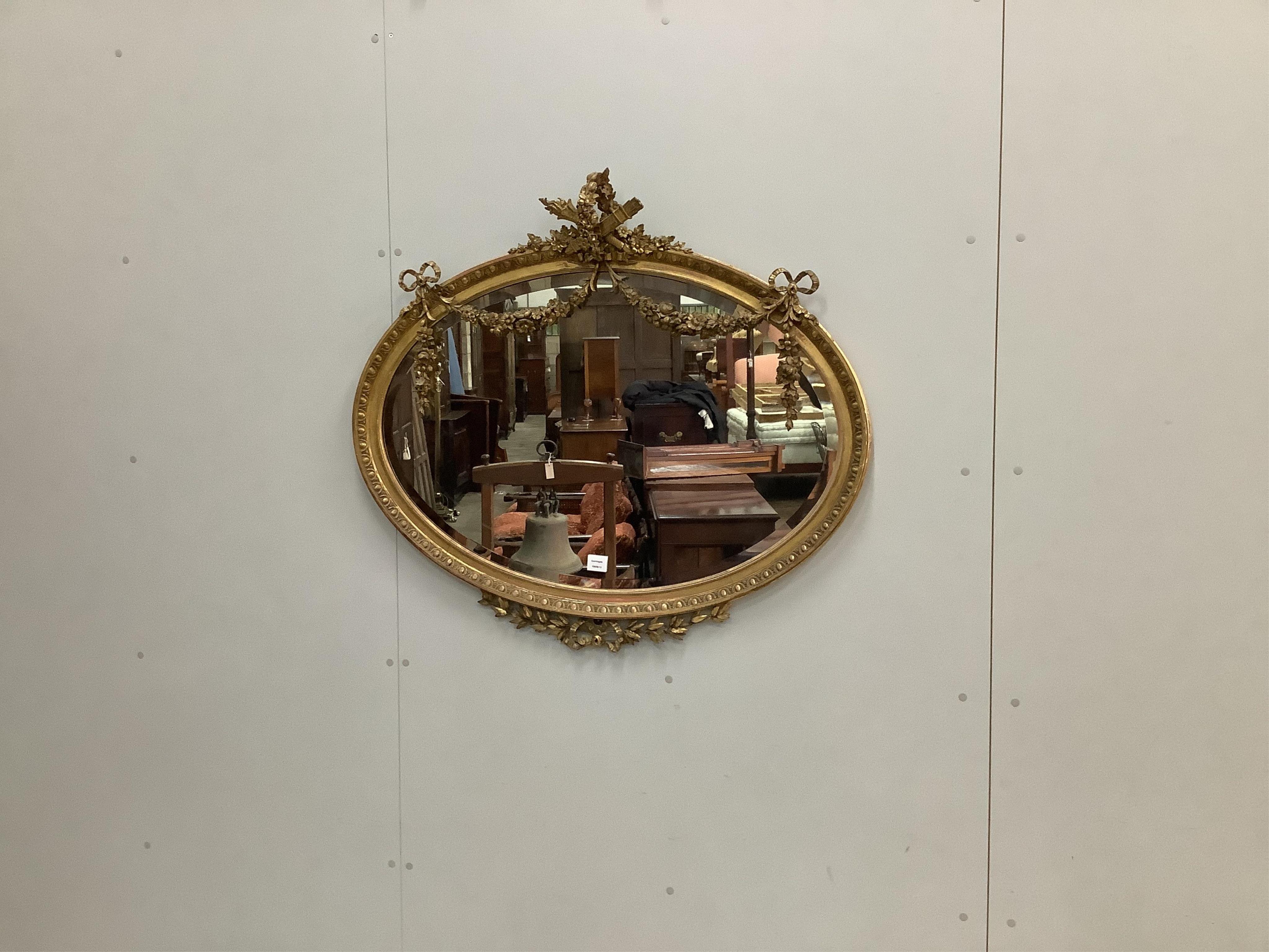 An Edwardian oval giltwood and composition wall mirror, width 105cm, height 95cm. Condition - fair to good